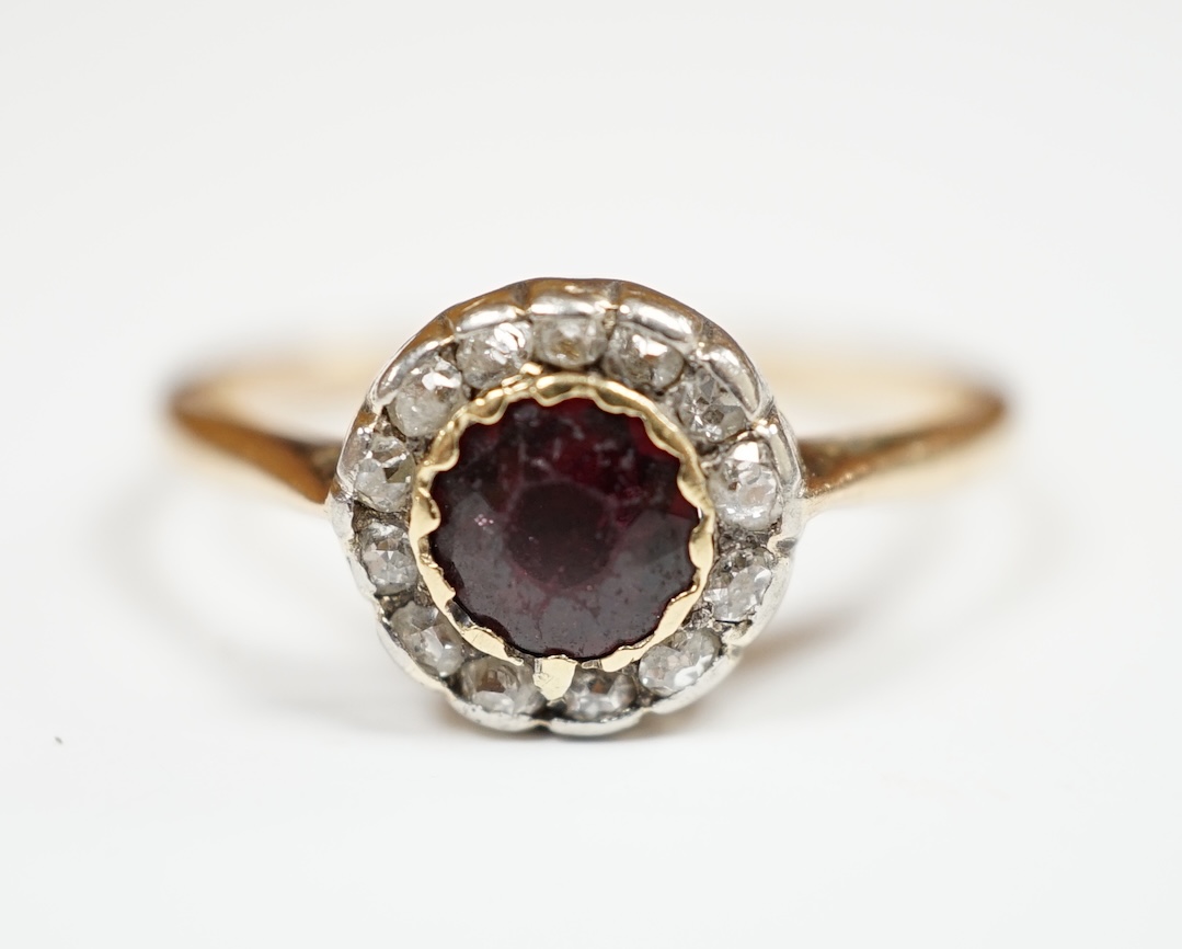 A 9ct, garnet and diamond set circular cluster ring, size R, gross weight 2.8 grams. Condition - poor